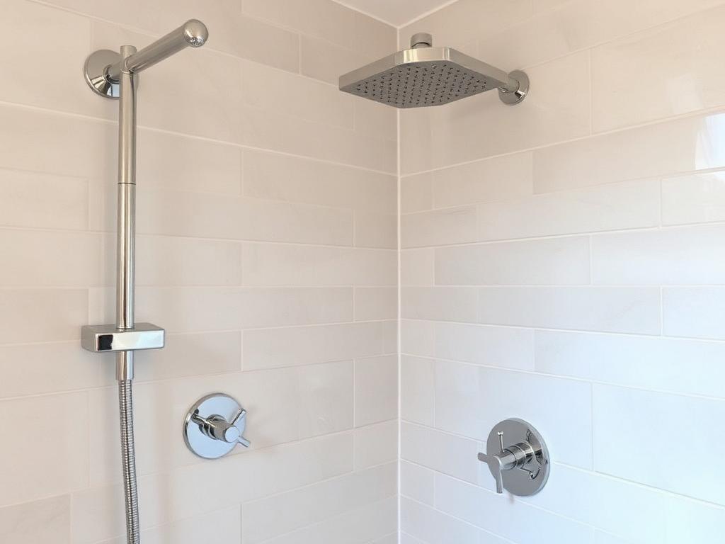 Newly installed chrome shower head and fixtures in a tiled shower